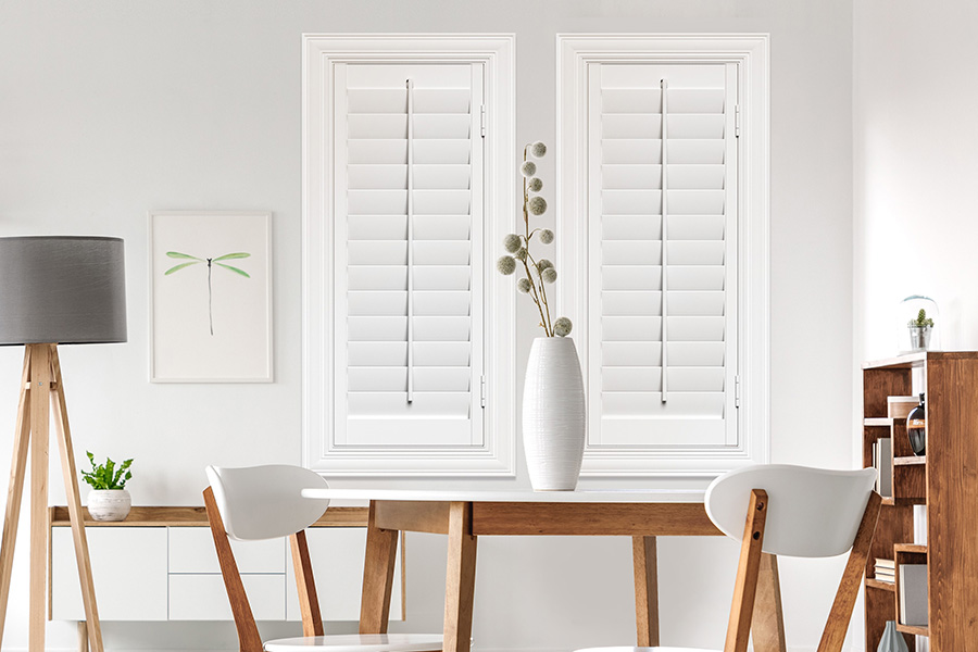 White Polywood shutters on two windows in a modern Scandinavian-style room