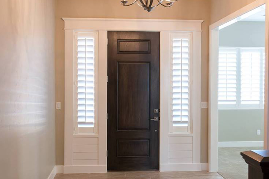 Sidelights with white polywood shutters in a foyer.