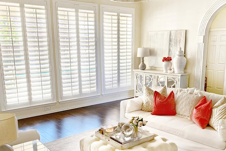Long white polywood shutters in a beige and off-white styled living room.